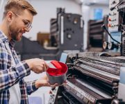 Man working in printing house with paper and paints